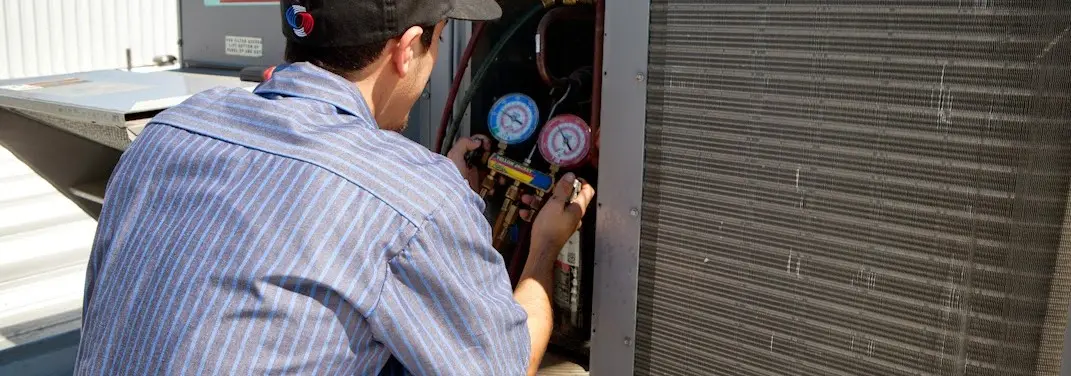 HVAC technician servicing a condenser unit in Vienna